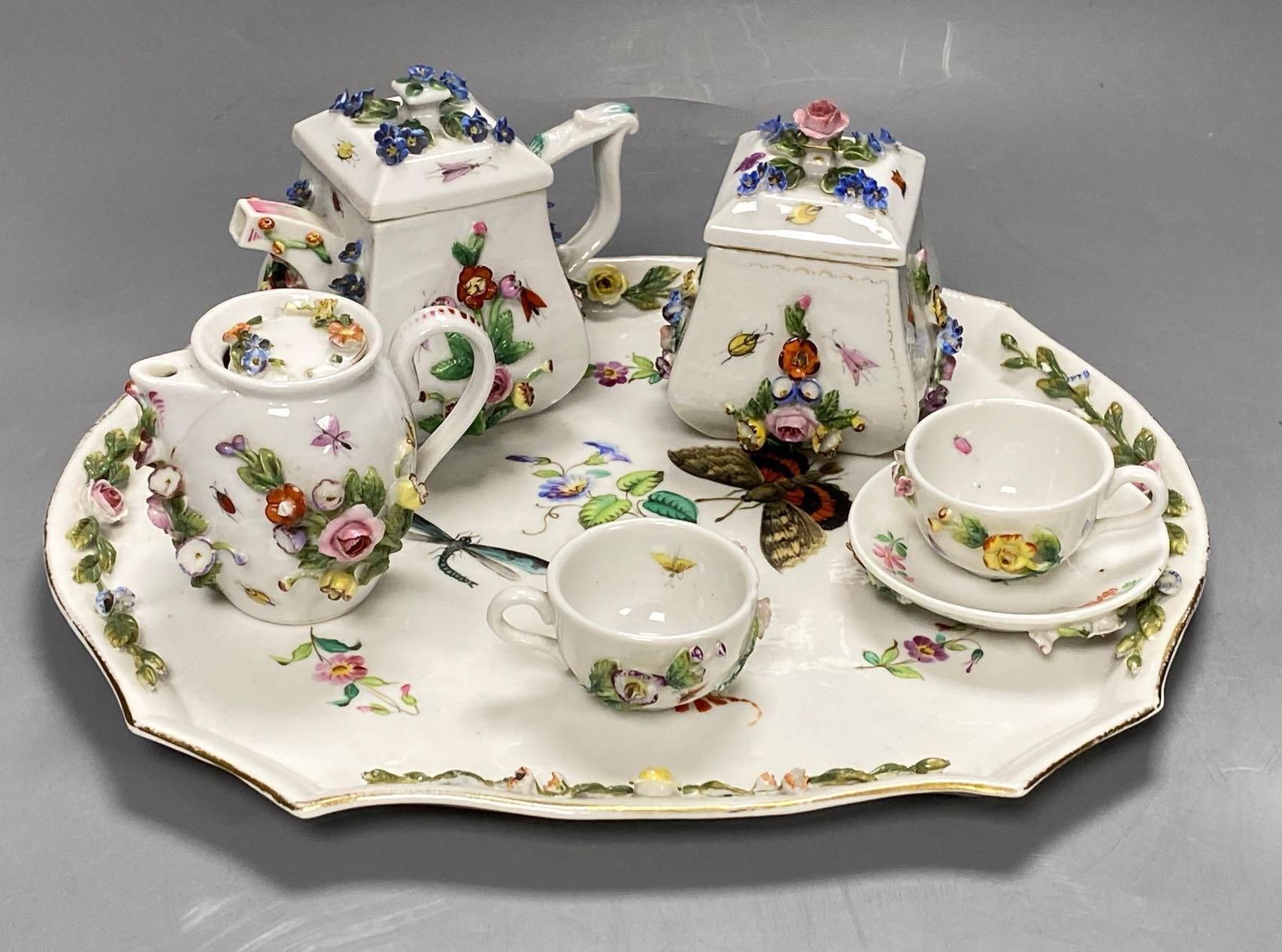 A late 19th century French porcelain flower encrusted cafe au lait set, on stand, stand 27cm